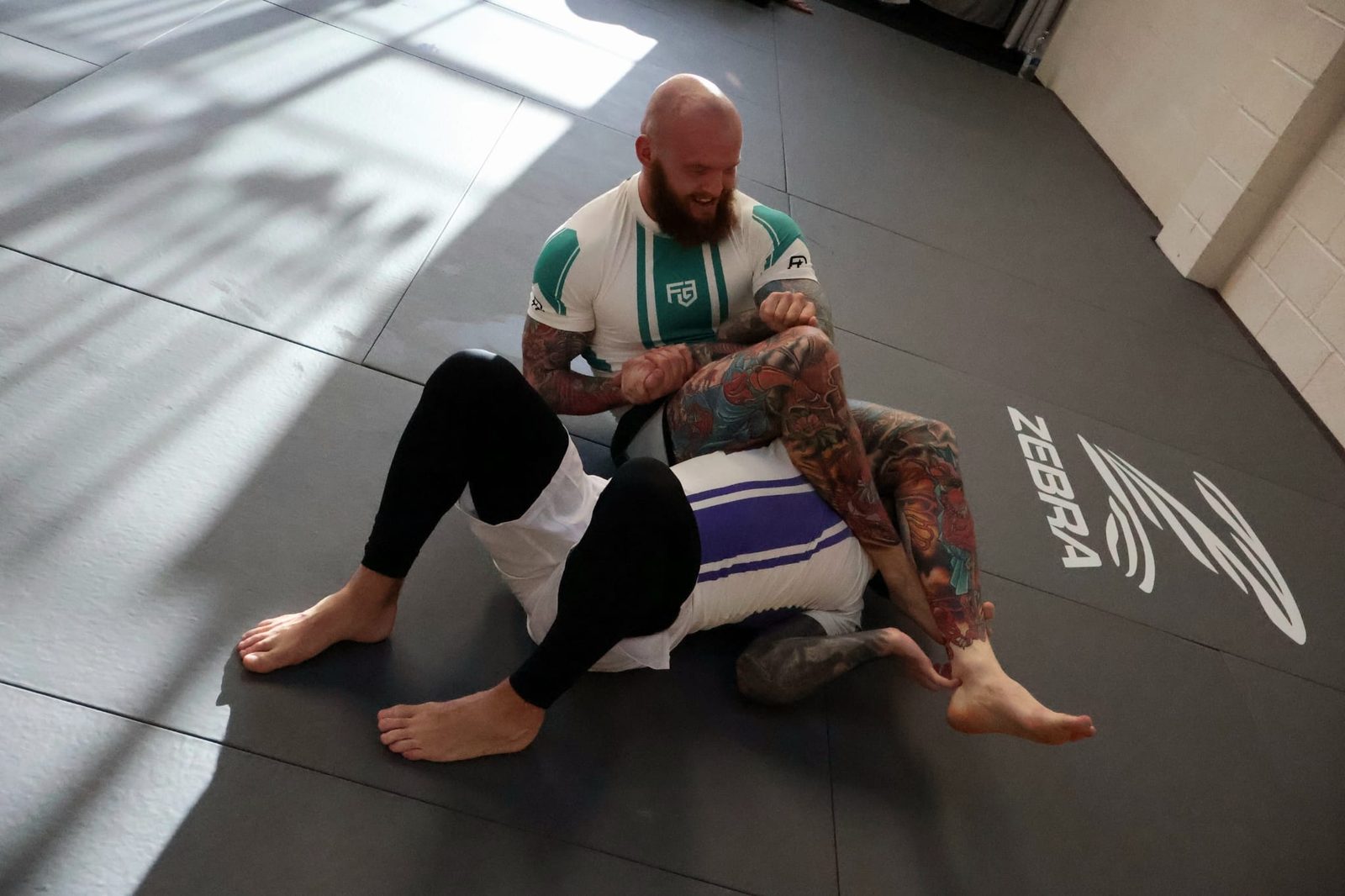 Members working from the guard position on the mats at Forged Grappling