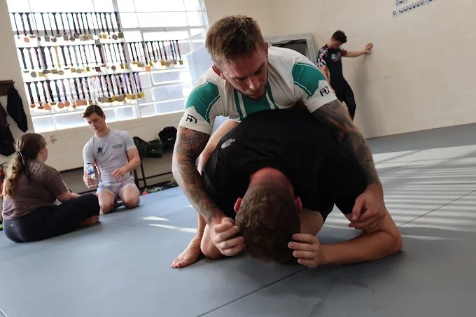 Members drilling a takedown on the mats at Forged Grappling, Westbury