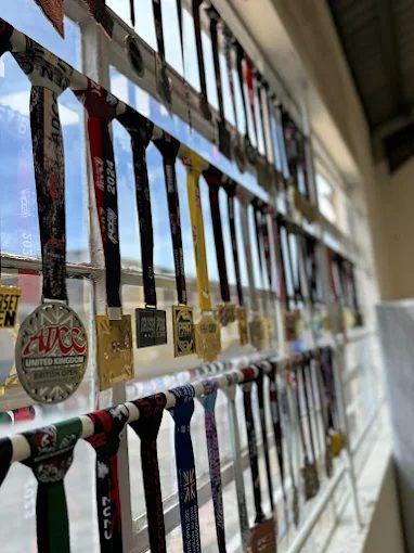 Competition medals won by Forged Grappling members, displayed at the gym